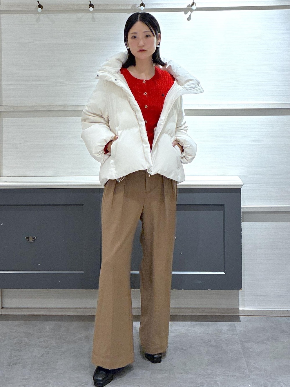 ブラック系のタンクトップ、ホワイト系のダウンジャケット/コート、ブラック系のブーツを着用したレディースの秋コーディネートの1枚目の写真