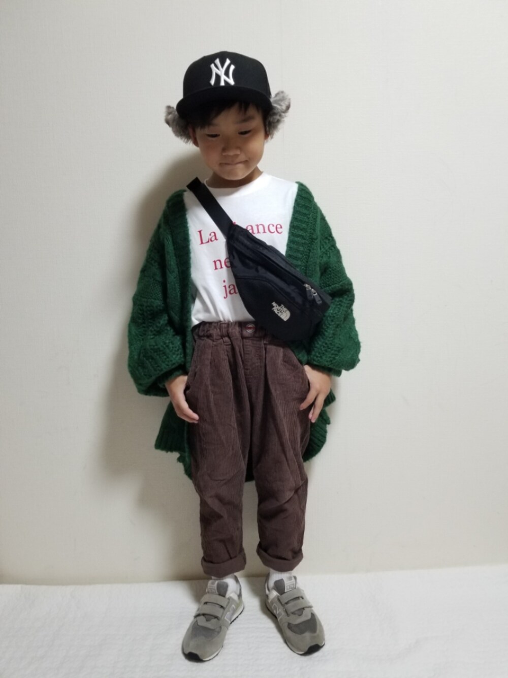 ホワイト系のTシャツ/カットソー、グリーン系のカーディガン/ボレロ、ブラウン系のその他パンツを着用したキッズの秋コーディネートの1枚目の写真