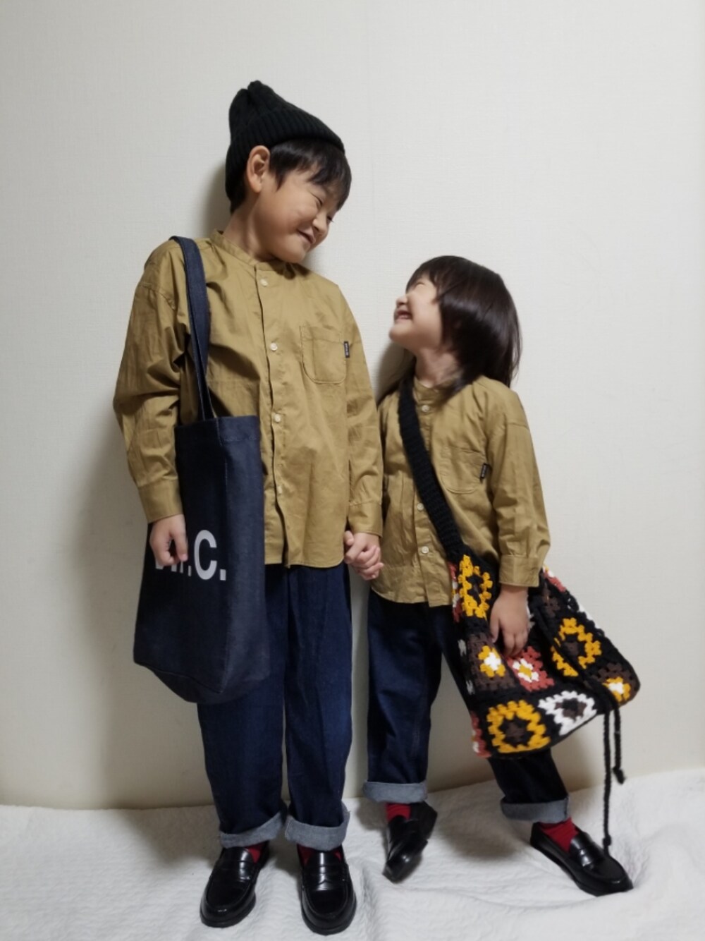 ベージュ系のシャツ/ブラウス、ブルー系のトートバッグ、ブラック系のショルダーバッグを着用したキッズの秋コーディネートの1枚目の写真