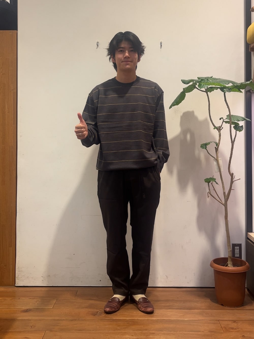 グレー系のニット/セーター、ブラウン系のその他パンツを着用したメンズの秋コーディネートの1枚目の写真
