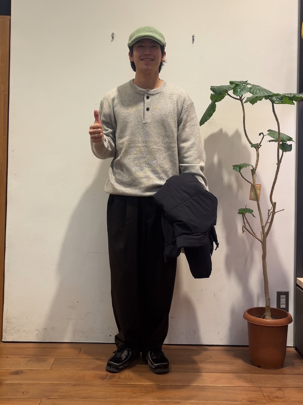 グレー系のニット/セーター、ブラック系のその他アウター、ブラウン系のその他パンツを着用したメンズの秋コーディネートの1枚目の写真