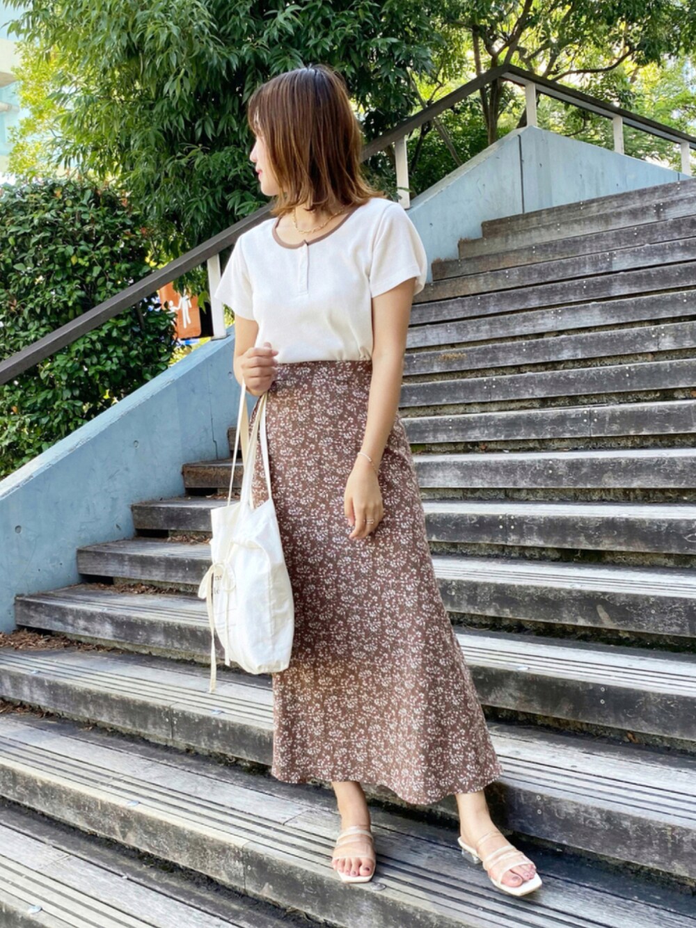 ホワイト系のTシャツ/カットソー、ブラウン系のスカート、ホワイト系のトートバッグを着用したレディースの夏コーディネートの1枚目の写真