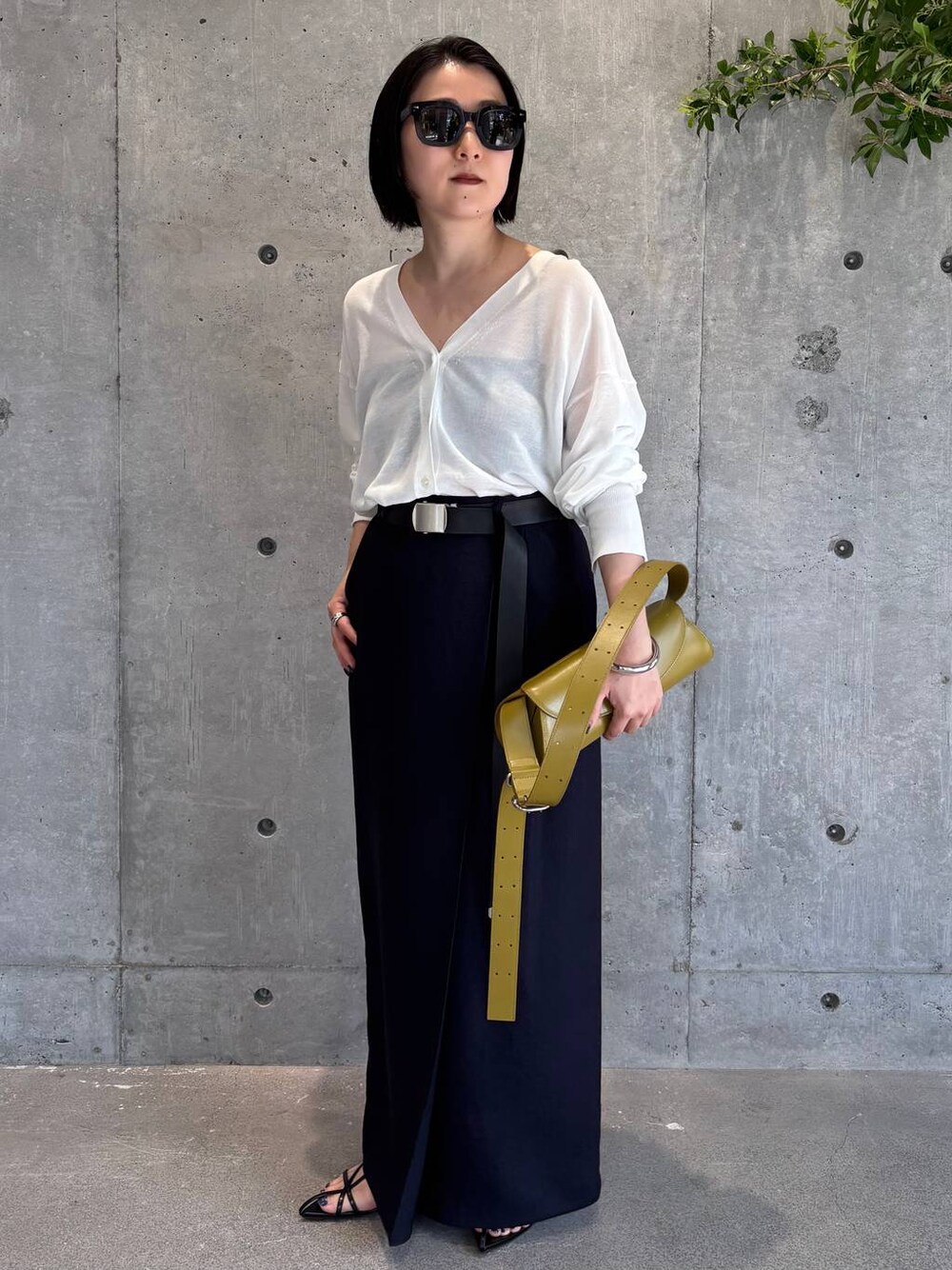 ホワイト系のカーディガン/ボレロ、ブルー系のスカート、ブラック系のベルトを着用したレディースの春コーディネートの1枚目の写真