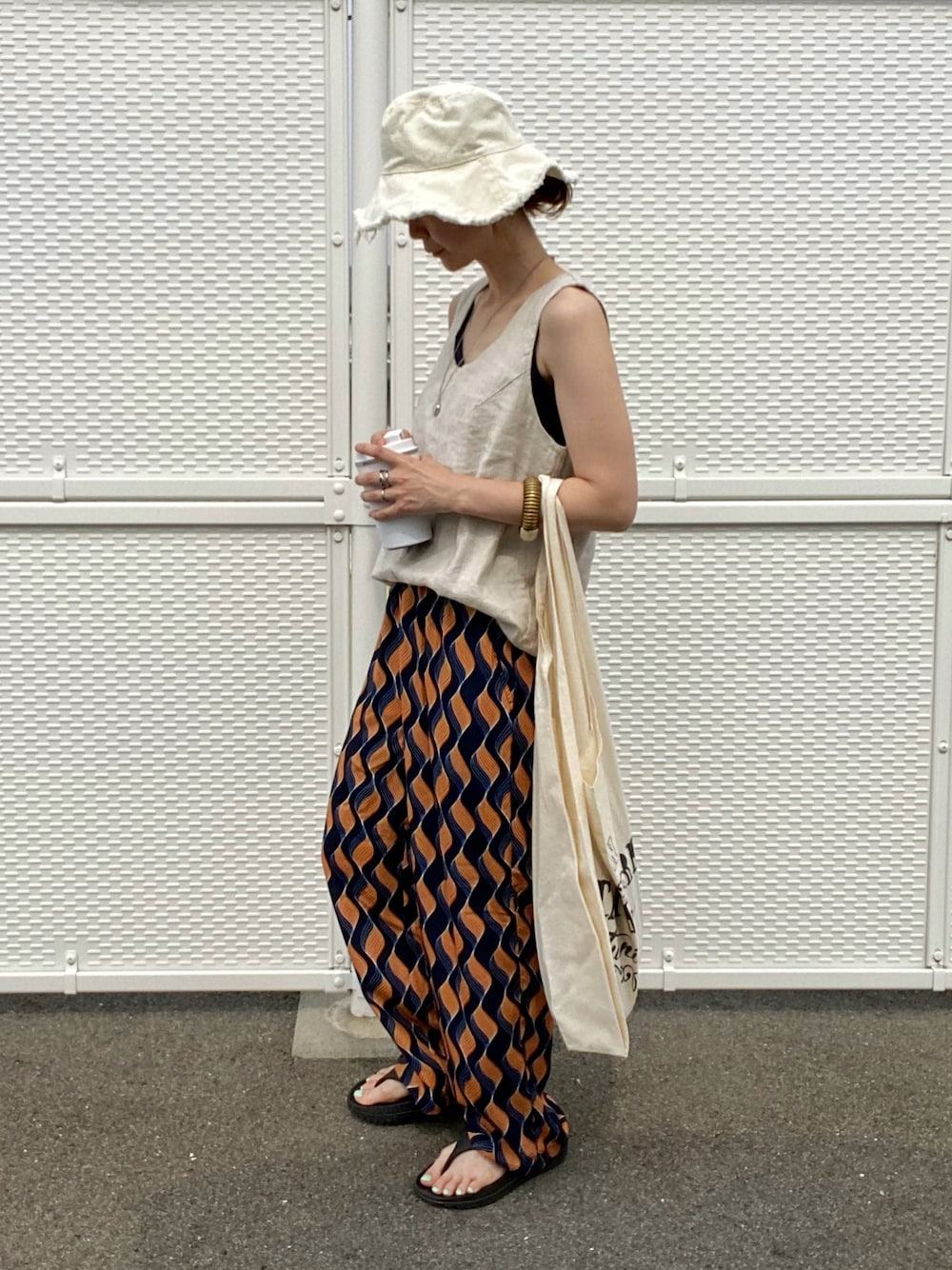 ブルー系のその他パンツ、ベージュ系のタンクトップ、その他のエコバッグ/サブバッグを着用したレディースの夏コーディネートの1枚目の写真