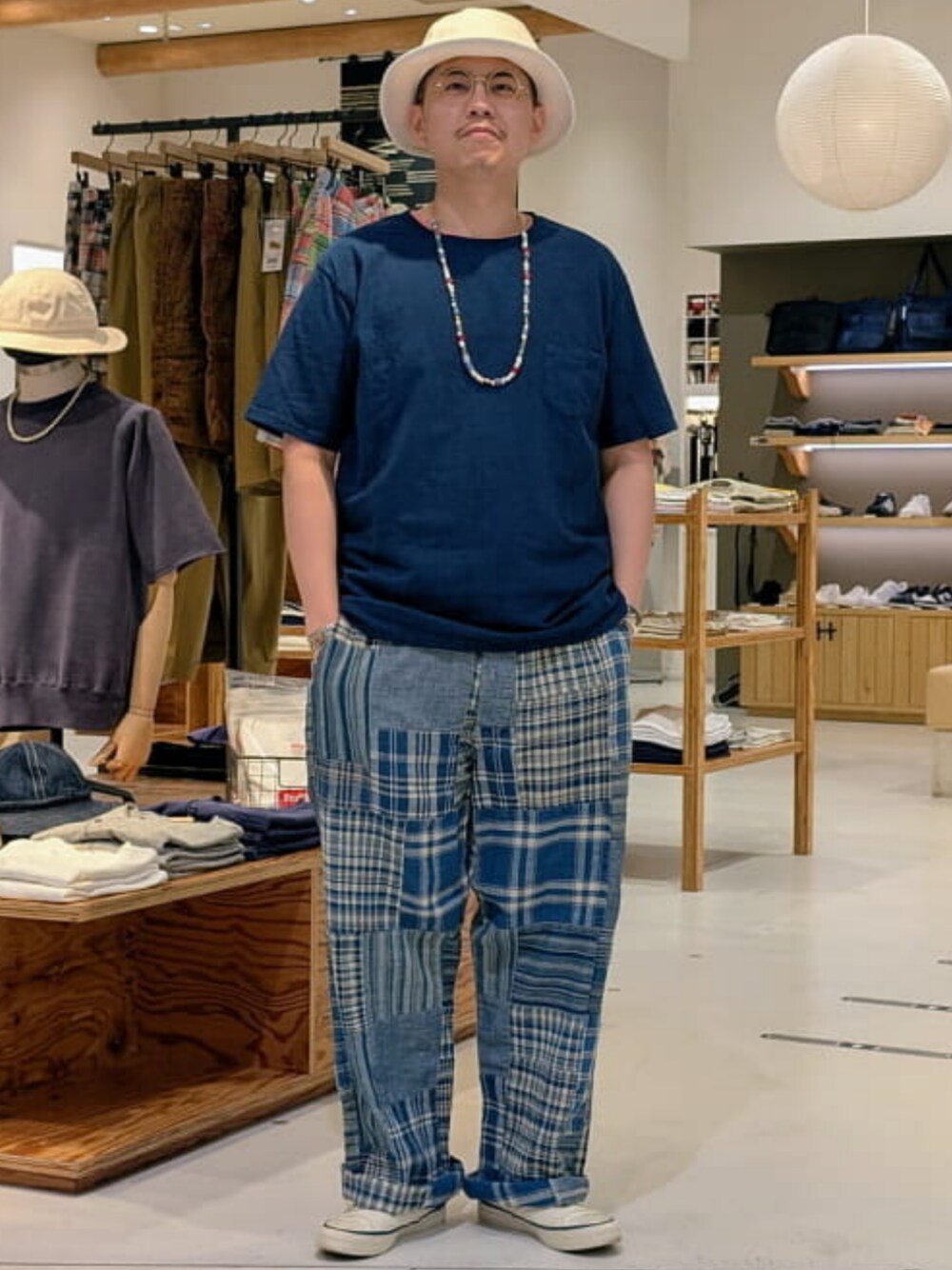 ホワイト系のスニーカー、ブルー系のTシャツ/カットソー、ベージュ系のハットを着用したメンズの夏コーディネートの1枚目の写真