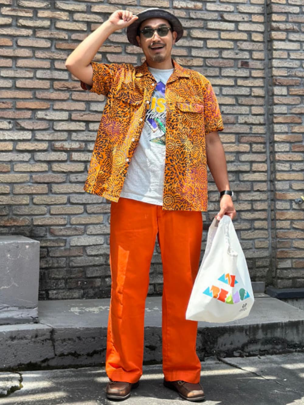 オレンジ系のその他パンツ、オレンジ系のシャツ/ブラウス、その他のハットを着用したメンズの夏コーディネートの1枚目の写真