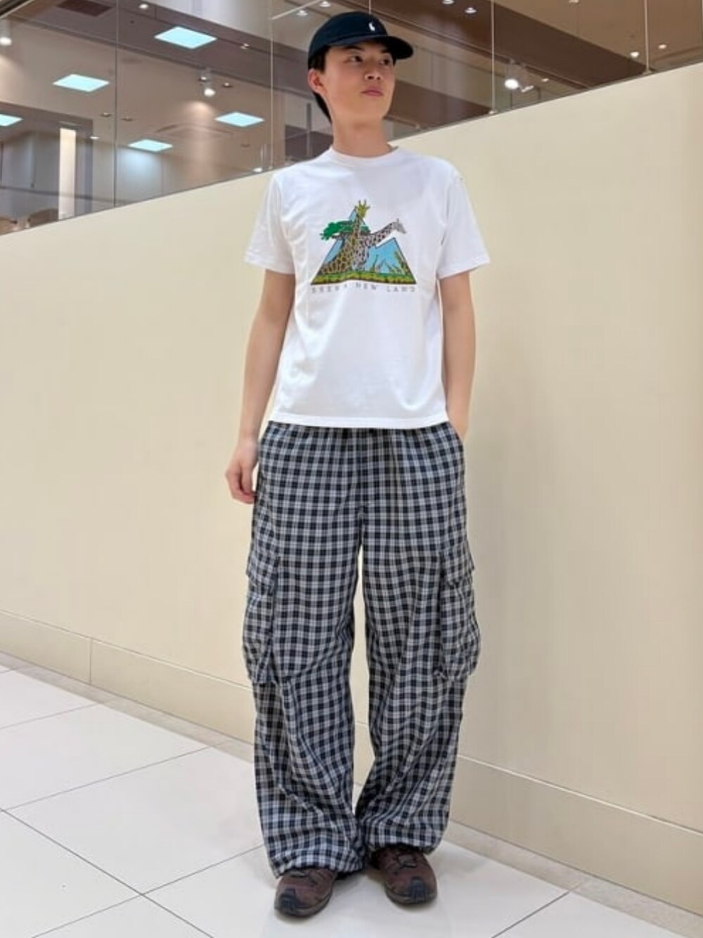 ホワイト系のTシャツ/カットソー、ブラック系のカーゴパンツを着用したメンズの春コーディネートの1枚目の写真