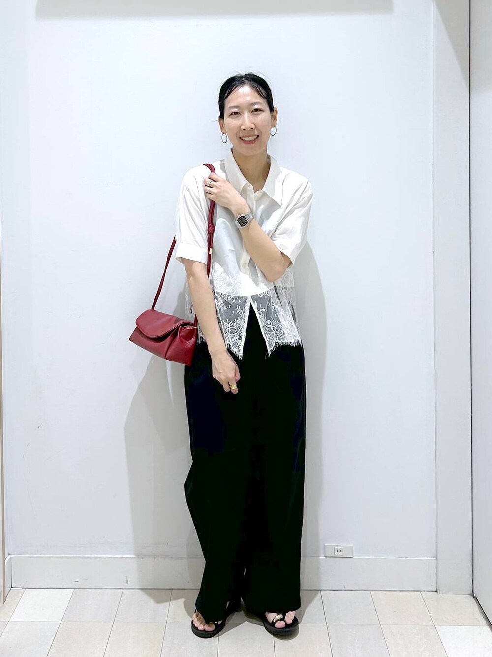 レッド系のショルダーバッグ、ブラック系のその他パンツ、ブラック系のサンダルを着用したレディースの夏コーディネートの1枚目の写真