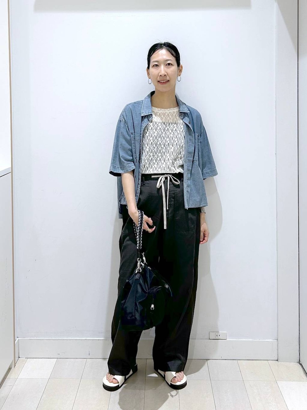 ブラック系のショルダーバッグ、ホワイト系のTシャツ/カットソー、ブルー系のシャツ/ブラウスを着用したレディースの夏コーディネートの1枚目の写真