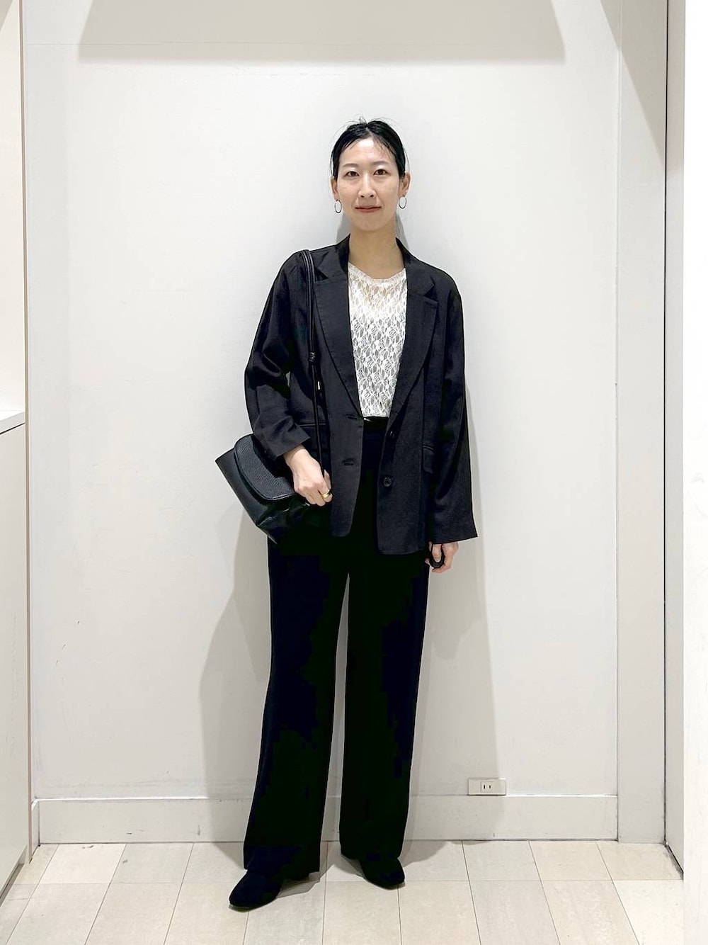 ブラック系のローファー、ブラック系のショルダーバッグ、ブラック系のテーラードジャケットを着用したレディースの春コーディネートの1枚目の写真