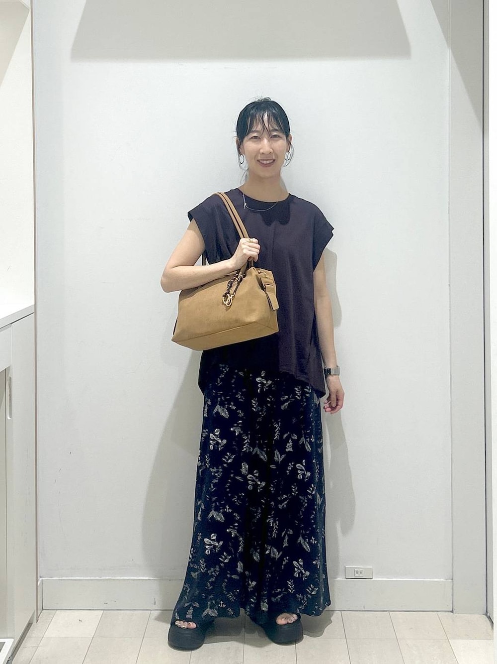 ブラック系のサンダル、ブラウン系のTシャツ/カットソー、ベージュ系のボストンバッグを着用したレディースの夏コーディネートの1枚目の写真