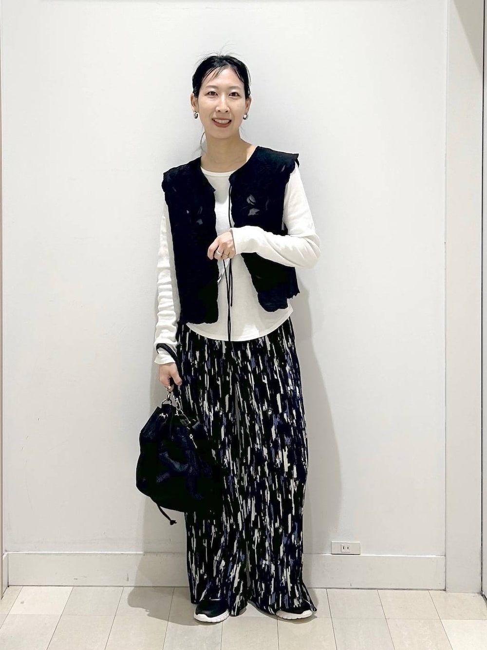 ブラック系のスニーカー、ブラック系のショルダーバッグ、ブルー系のその他パンツを着用したレディースの春コーディネートの1枚目の写真