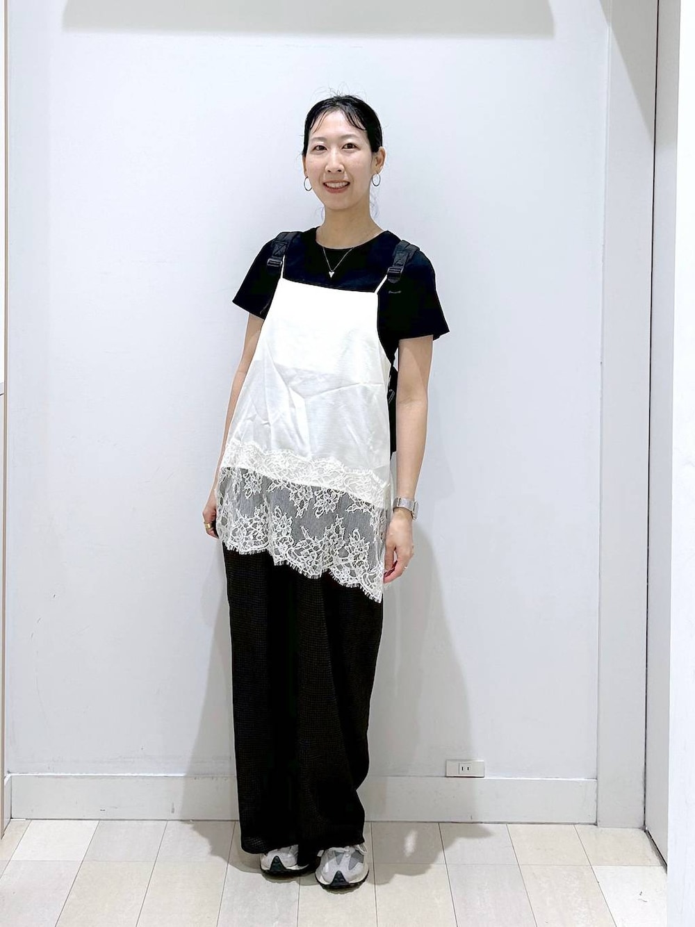 ブラック系のバックパック/リュック、ホワイト系のキャミソール、ホワイト系のTシャツ/カットソーを着用したレディースの夏コーディネートの1枚目の写真