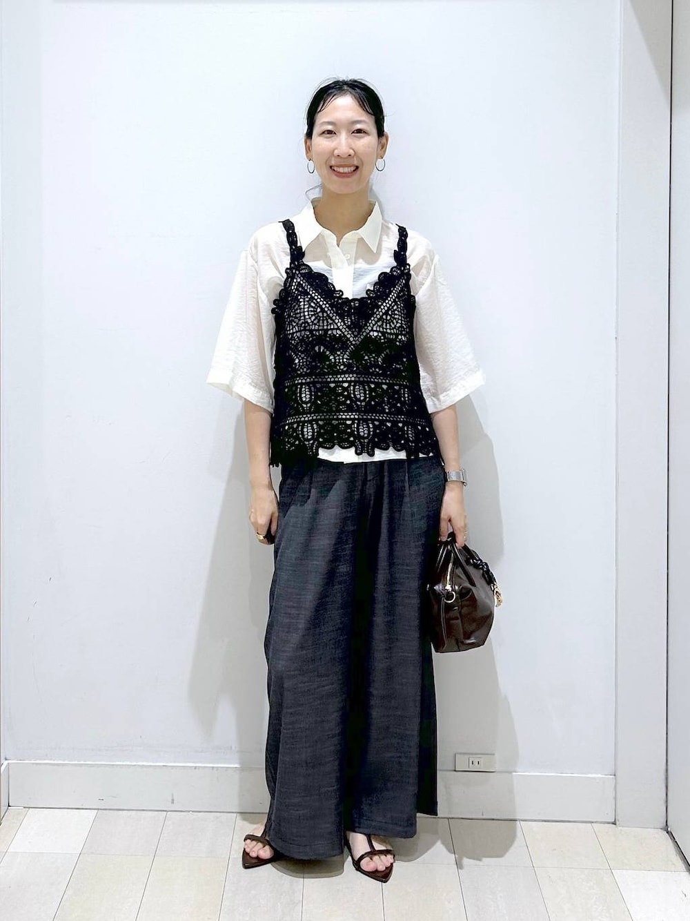 ブラック系のその他パンツ、ホワイト系のシャツ/ブラウス、ブラウン系のボストンバッグを着用したレディースの夏コーディネートの1枚目の写真