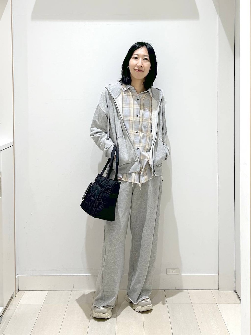 ブラック系のトートバッグ、ブルー系のシャツ/ブラウス、グレー系のパーカーを着用したレディースの春コーディネートの1枚目の写真