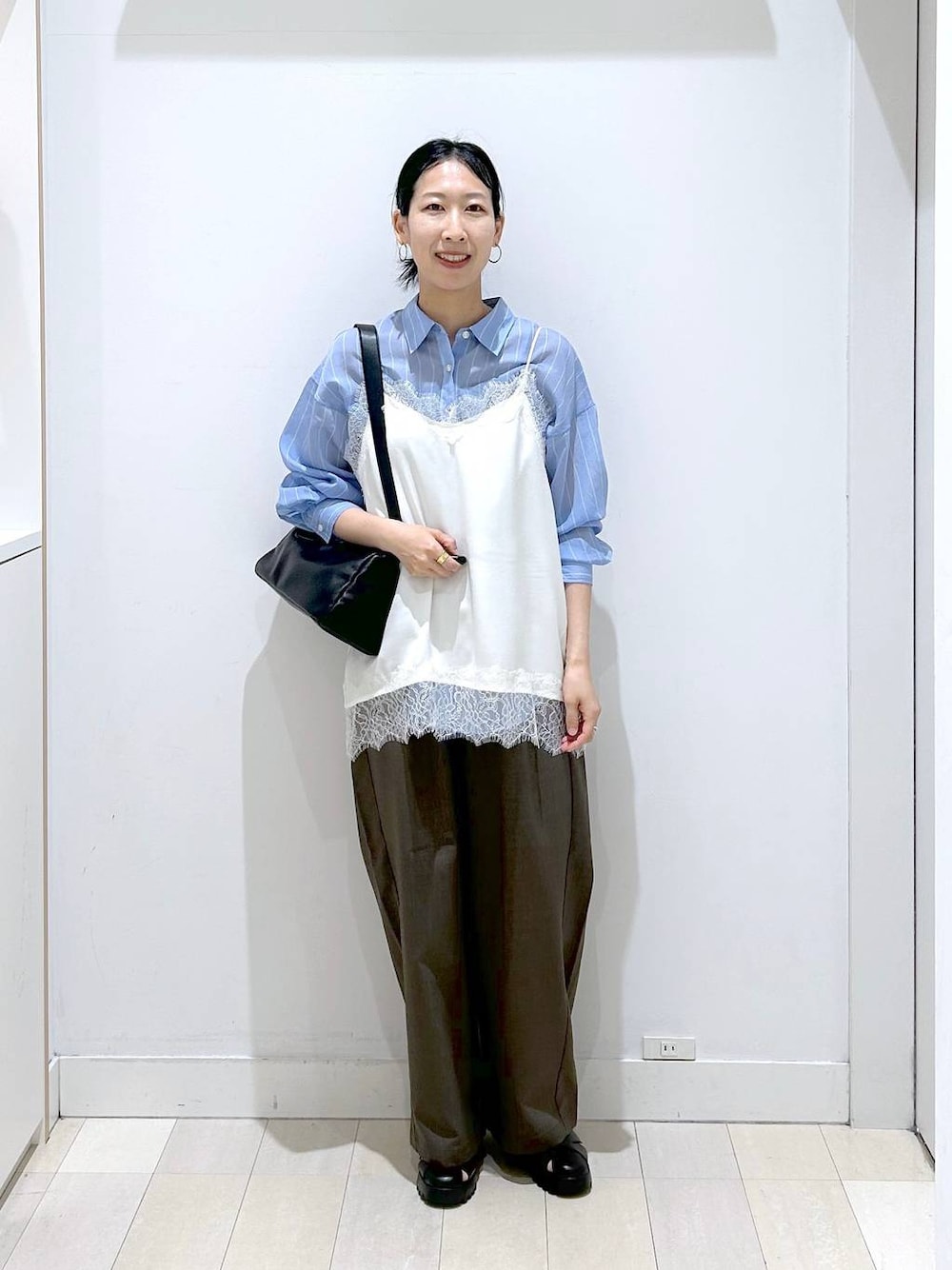 ブラウン系のその他パンツ、ブラック系のショルダーバッグ、ブルー系のシャツ/ブラウスを着用したレディースの春コーディネートの1枚目の写真