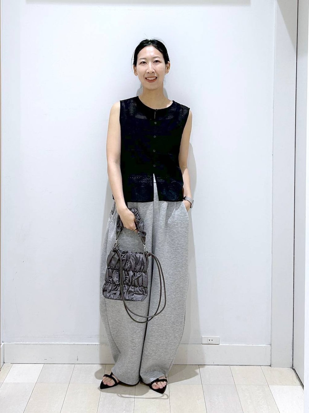 グレー系のトートバッグ、グレー系のその他パンツ、ブラック系のベストを着用したレディースの夏コーディネートの1枚目の写真