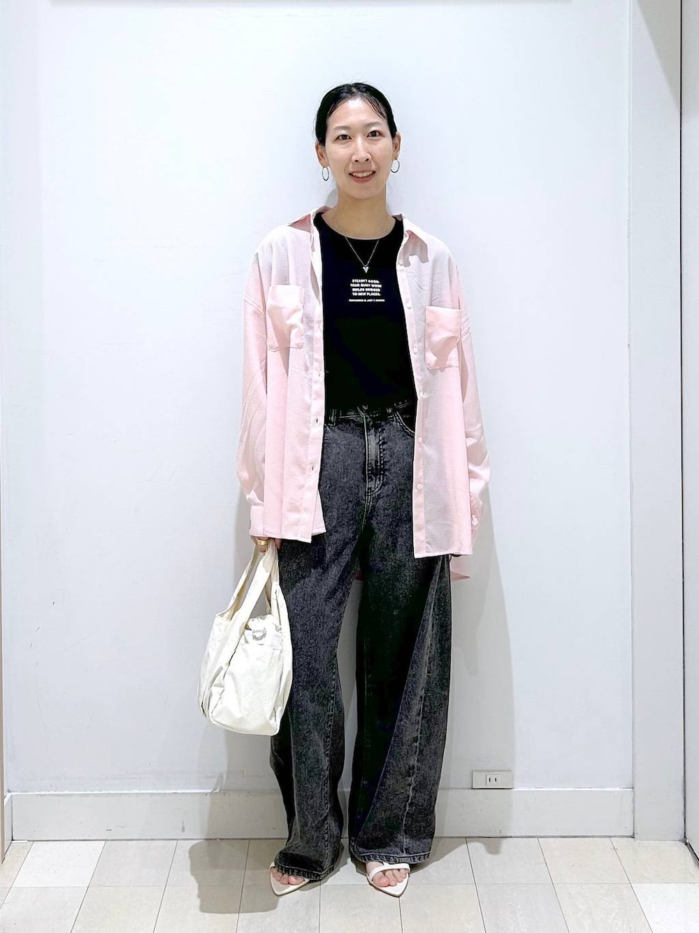 ホワイト系のトートバッグ、ブラック系のデニムパンツ、ブラック系のTシャツ/カットソーを着用したレディースの夏コーディネートの1枚目の写真