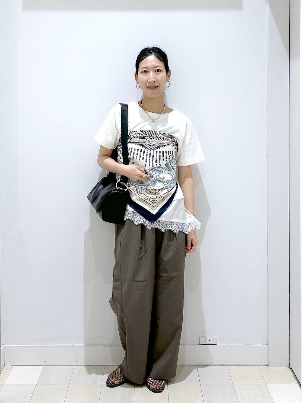 ブラウン系のその他パンツ、ブラック系のショルダーバッグ、ベージュ系のTシャツ/カットソーを着用したレディースの夏コーディネートの1枚目の写真