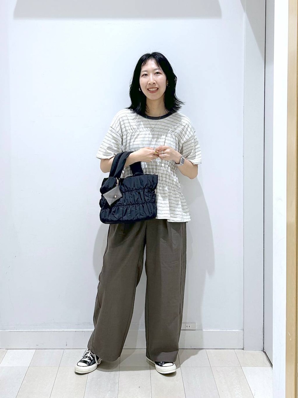ブラック系のトートバッグ、ブラウン系のその他パンツ、ホワイト系のTシャツ/カットソーを着用したレディースの夏コーディネートの1枚目の写真