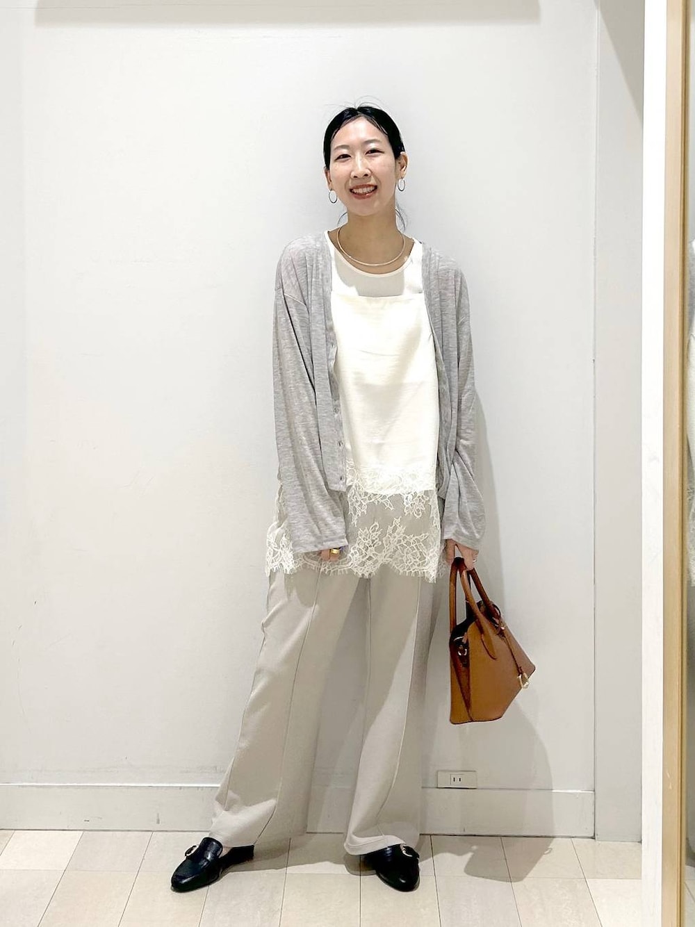 ブラック系のローファー、ブラウン系のショルダーバッグ、ベージュ系のその他パンツを着用したレディースの春コーディネートの1枚目の写真