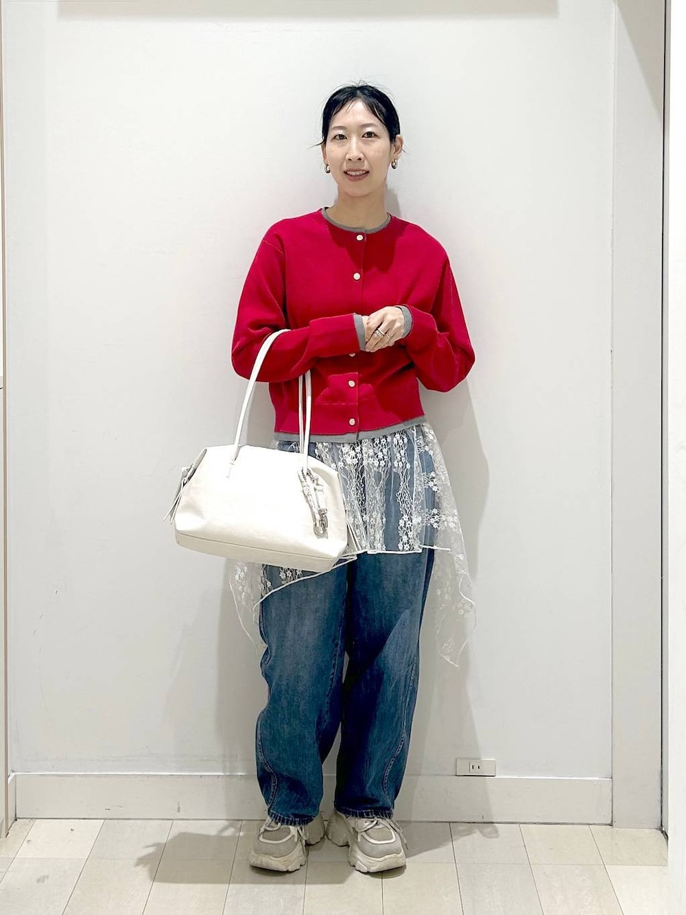 ホワイト系のボストンバッグ、ブルー系のデニムパンツ、ホワイト系のその他トップスを着用したレディースの春コーディネートの1枚目の写真