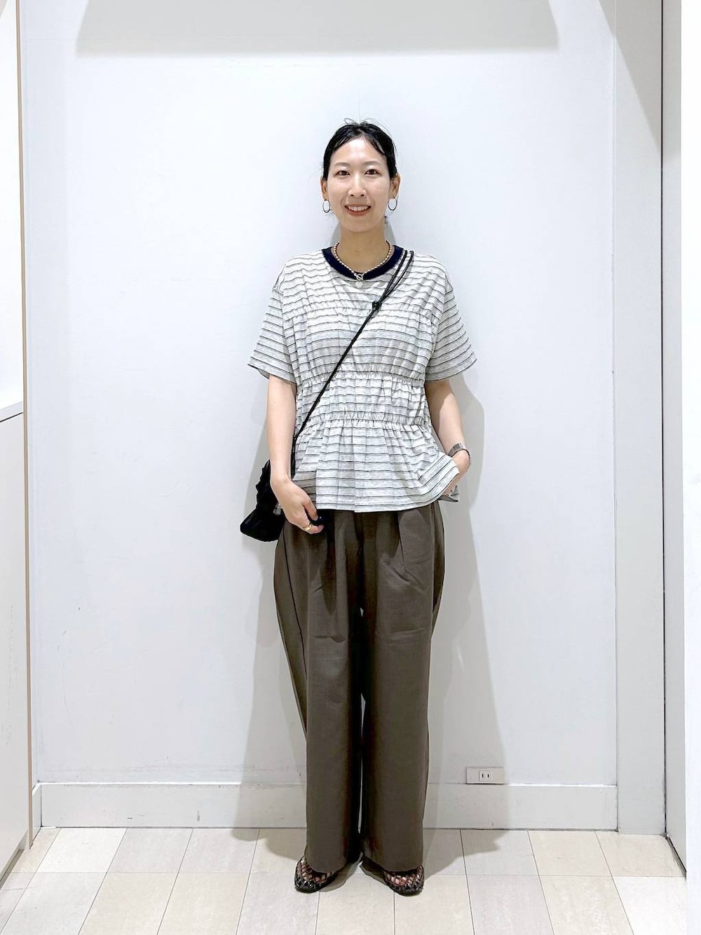 ブラウン系のその他パンツ、ブラック系のサンダル、グレー系のTシャツ/カットソーを着用したレディースの夏コーディネートの1枚目の写真