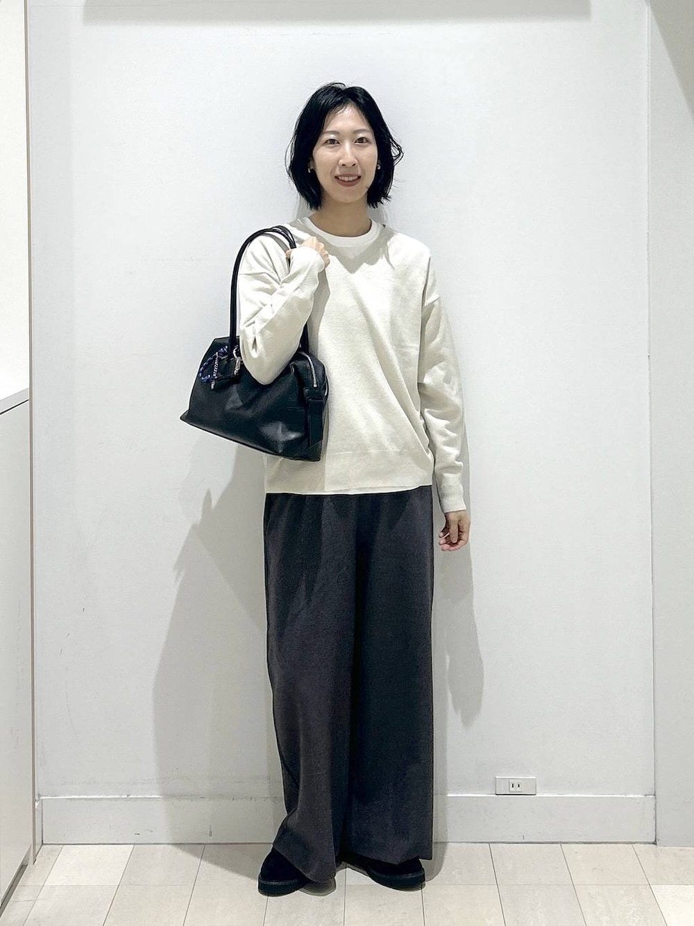 ブラック系のボストンバッグ、ブラック系のローファー、ホワイト系のTシャツ/カットソーを着用したレディースの秋コーディネートの1枚目の写真