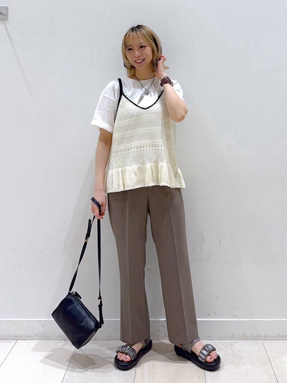 ブラウン系のその他パンツ、ホワイト系のTシャツ/カットソー、ブラック系のショルダーバッグを着用したレディースの春コーディネートの1枚目の写真