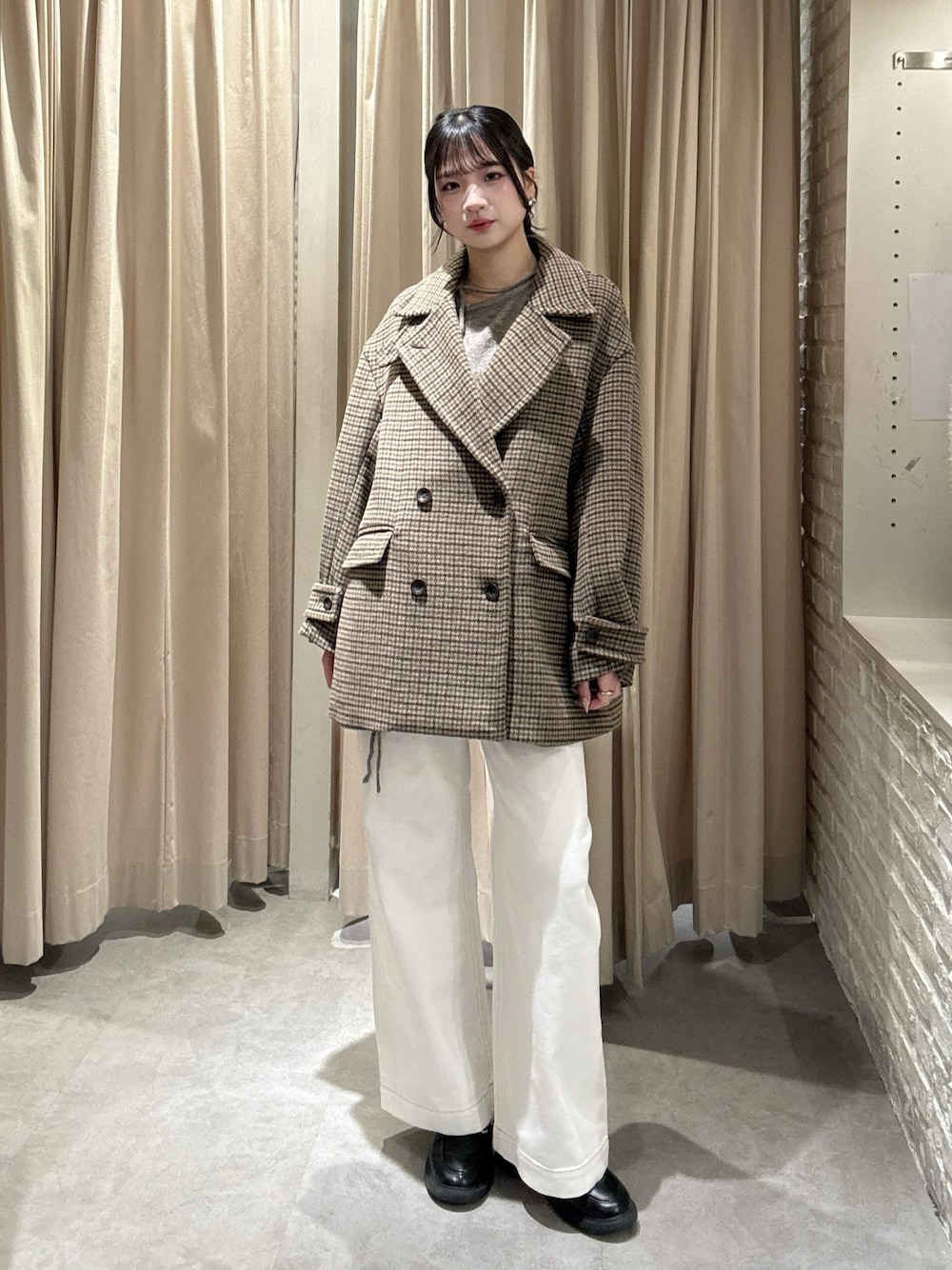 ベージュ系のピーコート、ホワイト系のデニムパンツ、ブラウン系のニット/セーターを着用したレディースの冬コーディネートの1枚目の写真