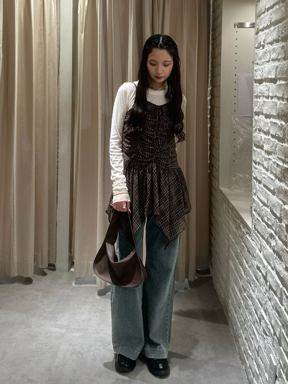 ブラウン系のワンピース、ホワイト系のTシャツ/カットソー、ブルー系のデニムパンツを着用したレディースの秋コーディネートの1枚目の写真