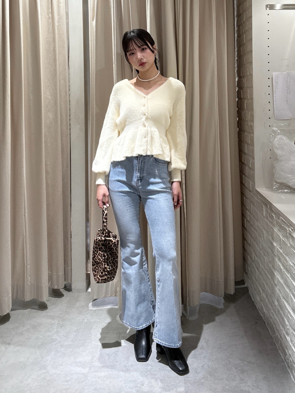 ホワイト系のニット/セーター、ブルー系のデニムパンツを着用したレディースの冬コーディネートの1枚目の写真