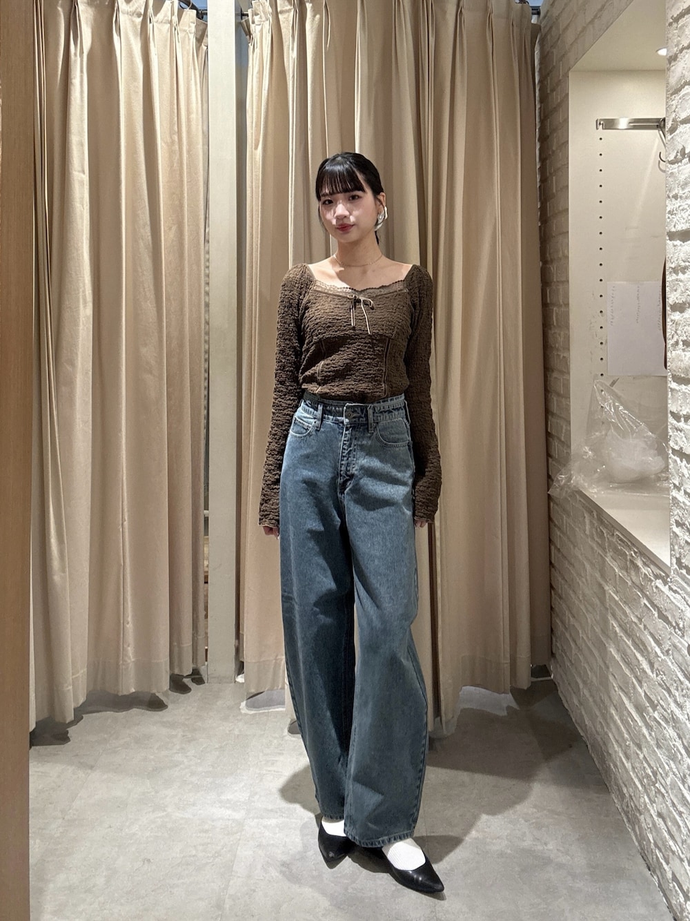 ブラウン系のTシャツ/カットソー、ブルー系のデニムパンツを着用したレディースの春コーディネートの1枚目の写真