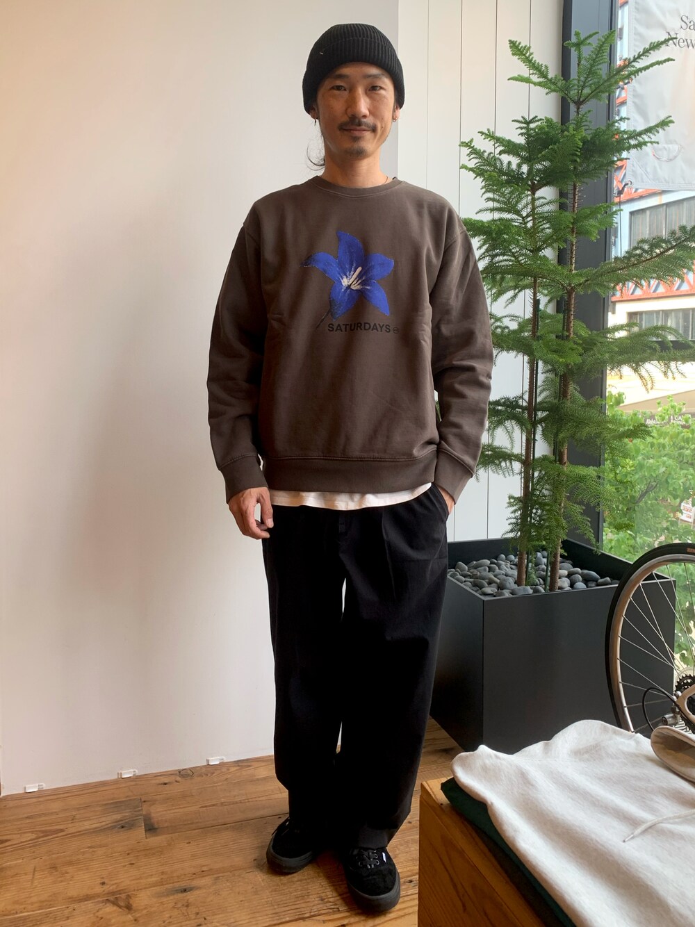「花柄、フローラル柄、ストリート、ワイドパンツ、ストリートMIX、ブラウン、秋コーデ、スウェット、ロン毛ニット帽」｜「Saturdays NYCのアイテム（ニットキャップ/ビーニー、ブラック系）」を使った、Ken.Nakamuraさん（メンズ・173cm）の秋コーディネートの1枚目の写真