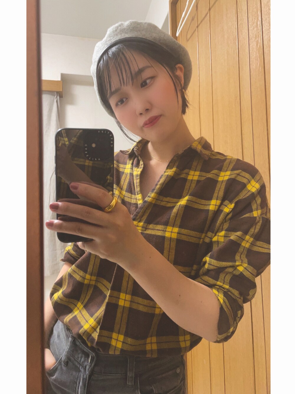 イエロー系のシャツ/ブラウス、グレー系のデニムパンツ、グレー系のハンチング/ベレー帽を着用したレディースの秋コーディネートの1枚目の写真
