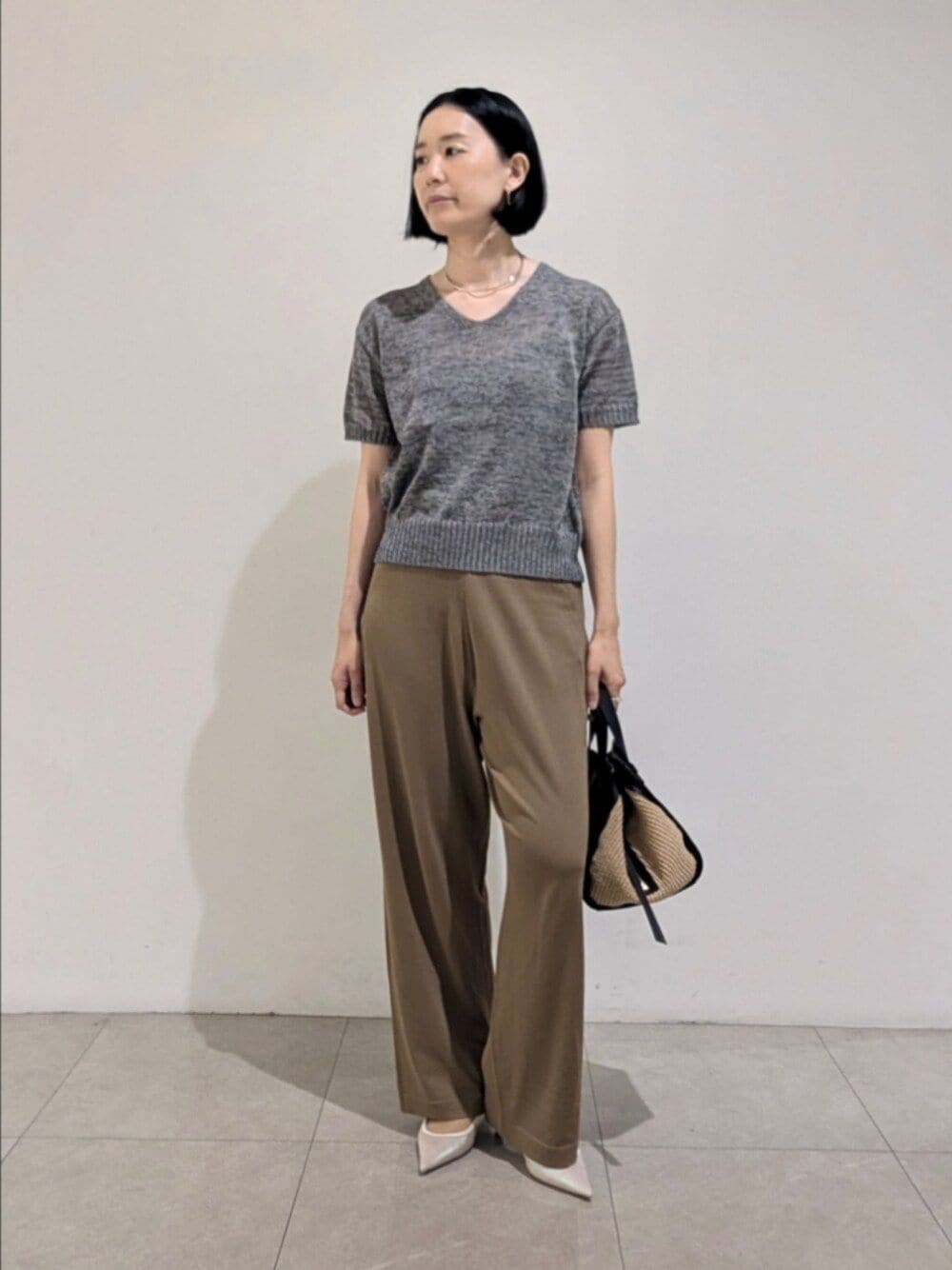 グレー系のニット/セーター、ベージュ系のその他パンツ、シルバー系のチョーカーを着用したレディースの夏コーディネートの1枚目の写真