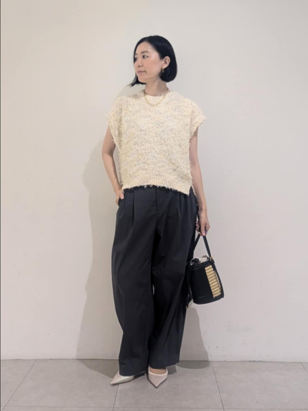 ホワイト系のニット/セーター、グレー系のその他パンツ、ゴールド系のネックレスを着用したレディースの夏コーディネートの1枚目の写真