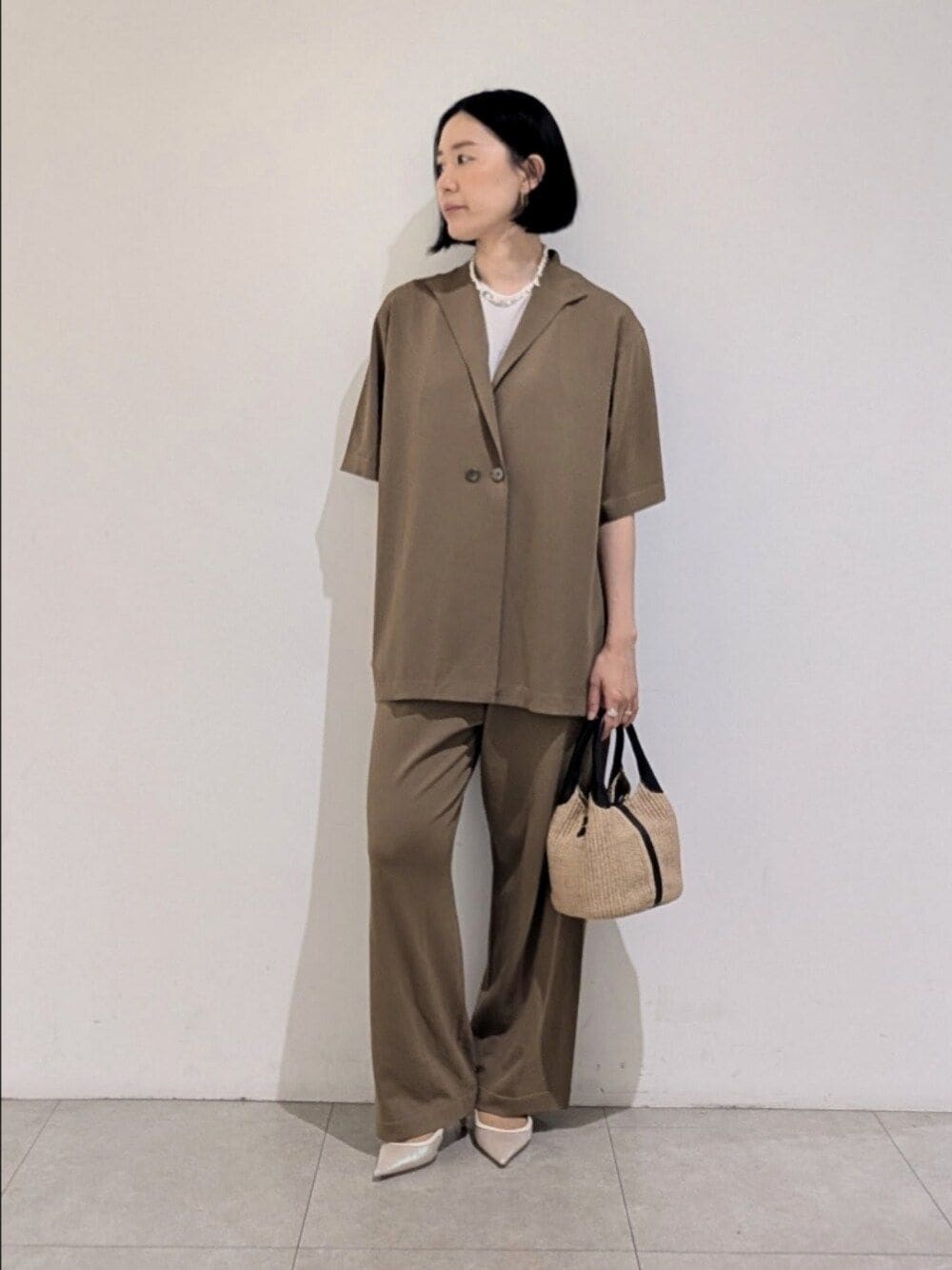 ベージュ系のその他パンツ、ベージュ系のテーラードジャケット、ホワイト系のタンクトップを着用したレディースの夏コーディネートの1枚目の写真