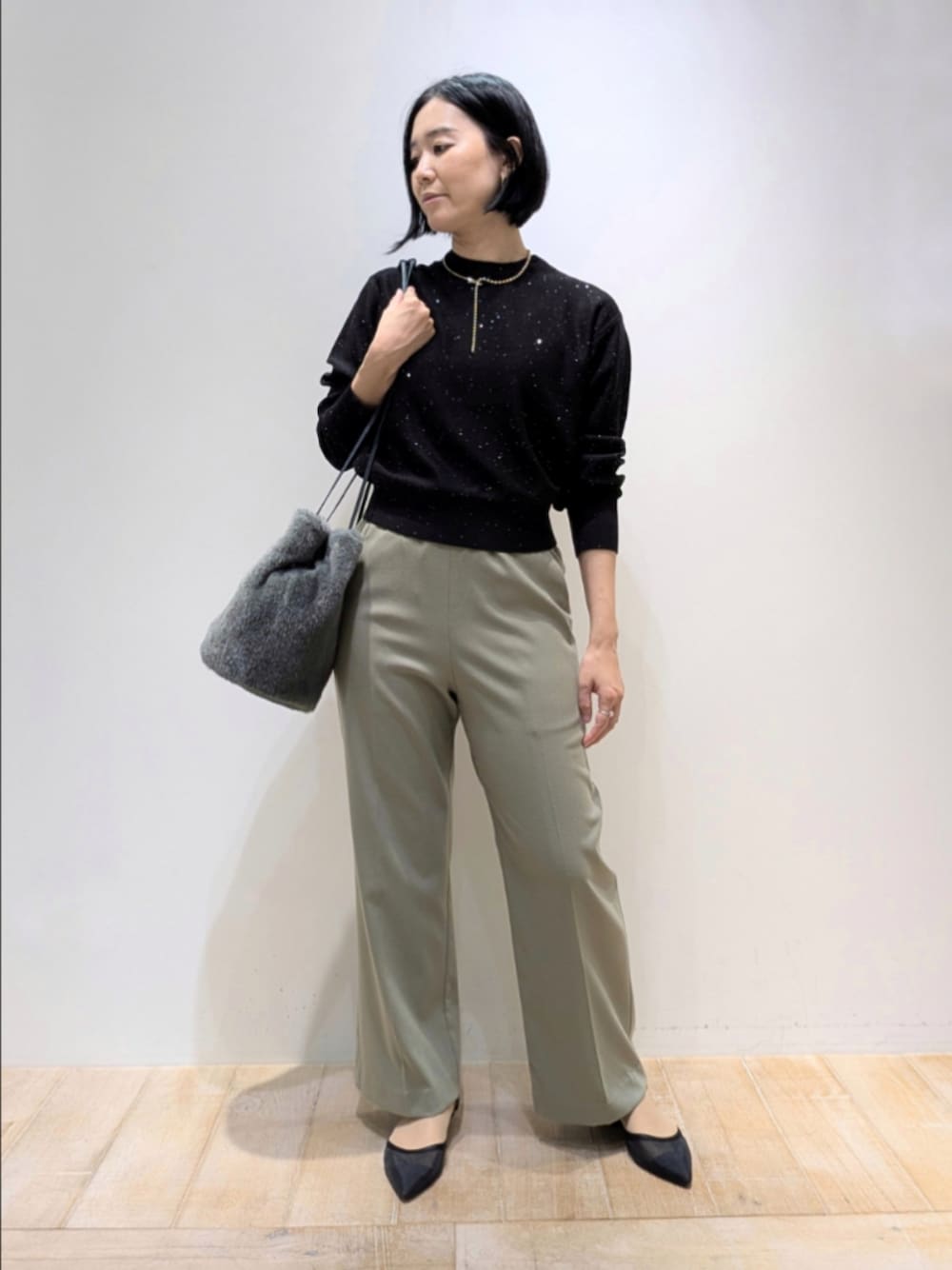 ブラック系のニット/セーター、グリーン系のその他パンツ、グリーン系のショルダーバッグを着用したレディースの秋コーディネートの1枚目の写真