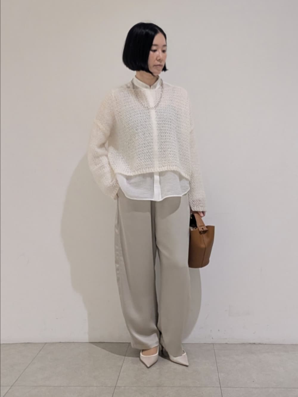 ホワイト系のニット/セーター、ホワイト系のシャツ/ブラウス、ベージュ系のその他パンツを着用したレディースの秋コーディネートの1枚目の写真