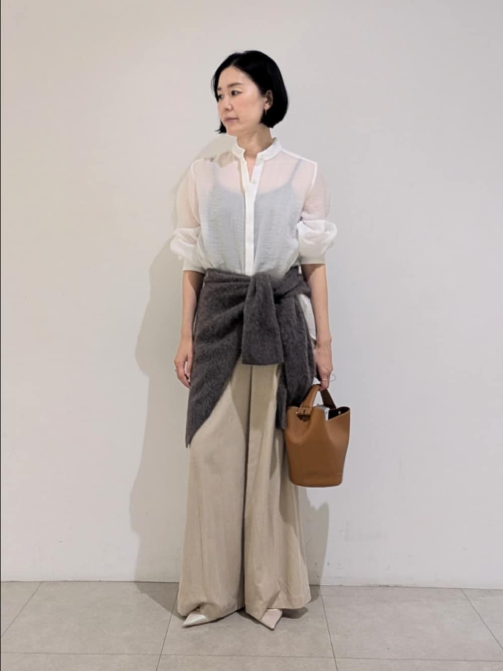 ホワイト系のシャツ/ブラウス、ベージュ系のその他パンツ、ブラウン系のストール/ショールを着用したレディースの秋コーディネートの1枚目の写真