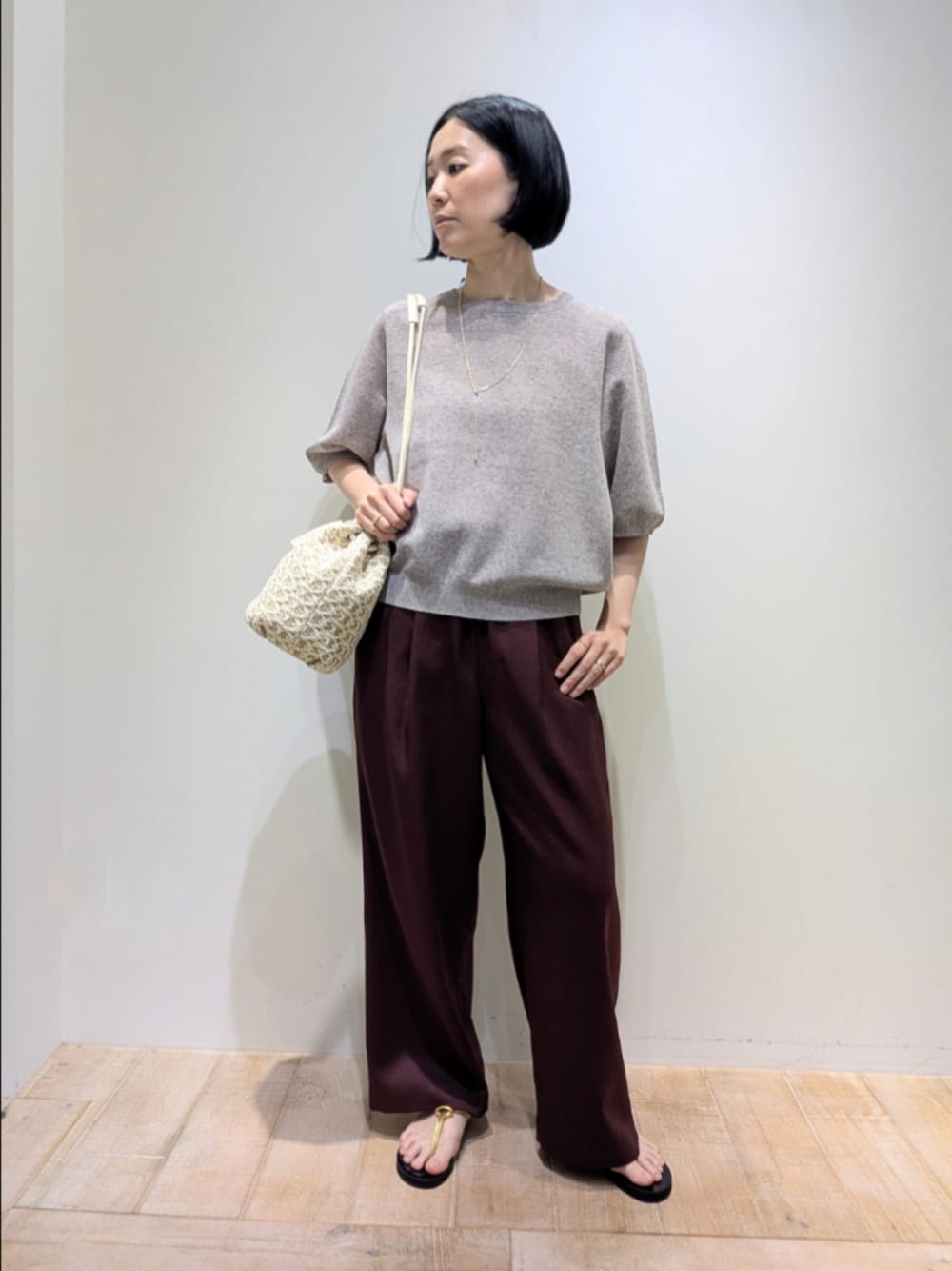 ホワイト系のショルダーバッグ、ブラウン系のニット/セーター、レッド系のその他パンツを着用したレディースの夏コーディネートの1枚目の写真