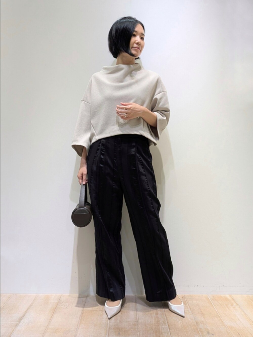 ブラック系のその他パンツ、ベージュ系のTシャツ/カットソーを着用したレディースの秋コーディネートの1枚目の写真