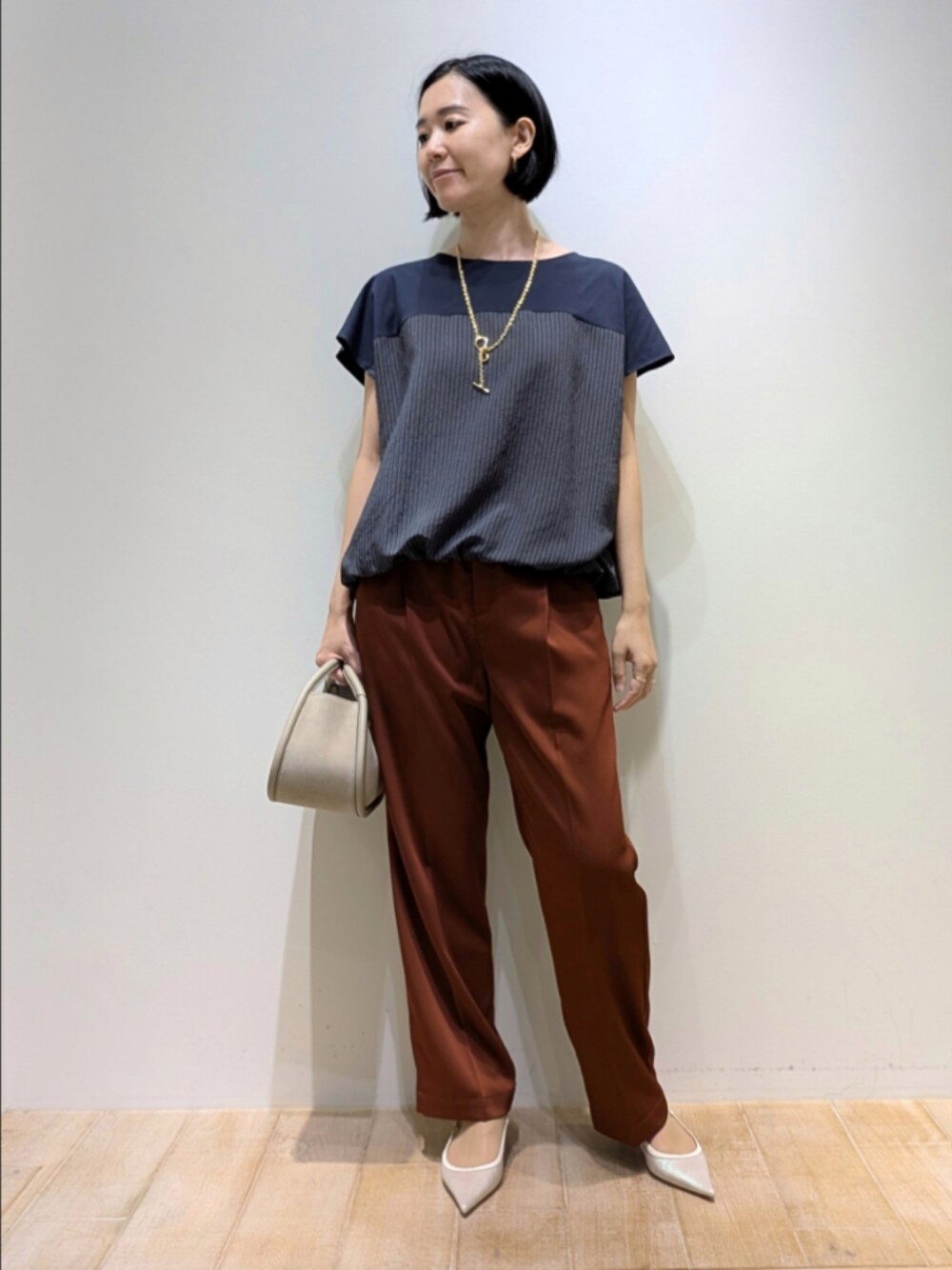 ブラウン系のその他パンツ、ブルー系のTシャツ/カットソー、ゴールド系のネックレスを着用したレディースの秋コーディネートの1枚目の写真