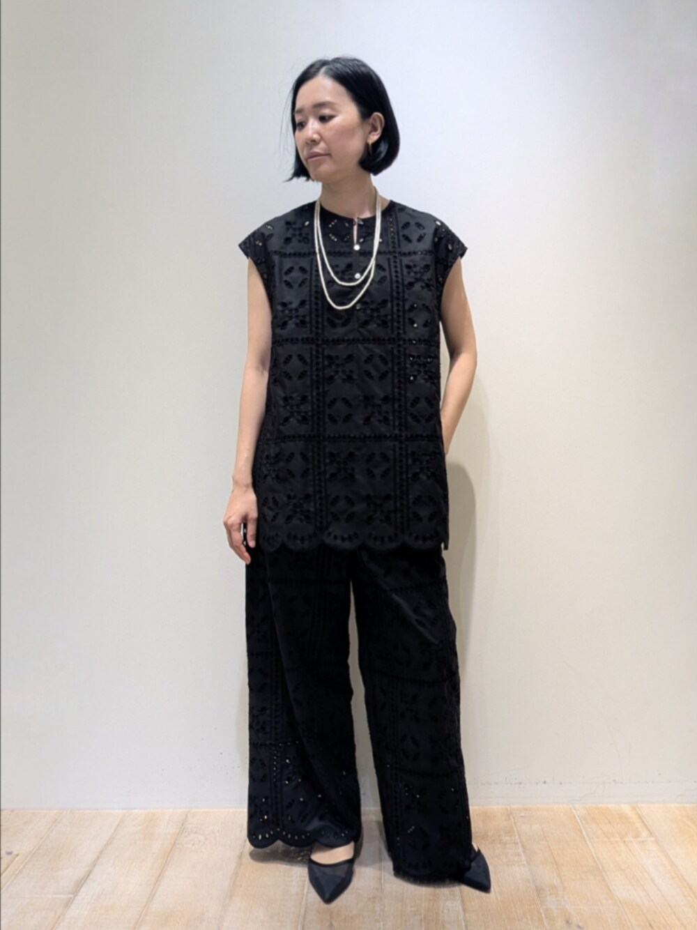 ブラック系のシャツ/ブラウス、ブラック系のその他パンツ、ホワイト系のネックレスを着用したレディースの夏コーディネートの1枚目の写真