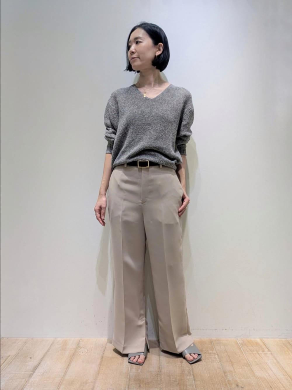 グレー系のニット/セーター、ベージュ系のその他パンツ、ブラウン系のベルトを着用したレディースの冬コーディネートの1枚目の写真