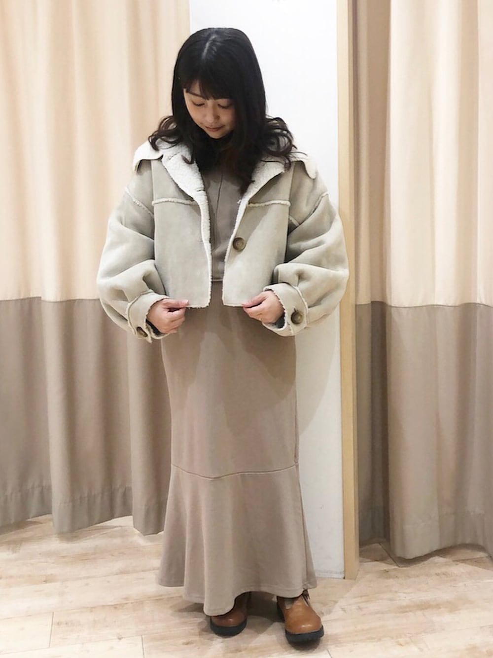 ホワイト系のその他アウター、ベージュ系のTシャツ/カットソー、ベージュ系のスカートを着用したレディースの冬コーディネートの1枚目の写真