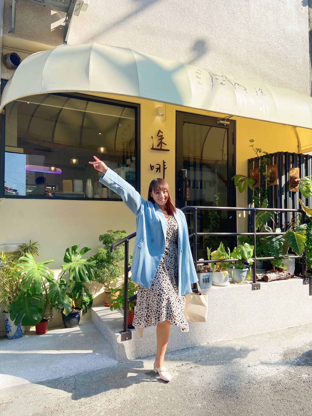 ブルー系のテーラードジャケット、ベージュ系のワンピース、ベージュ系のスリッポンを着用したレディースの冬コーディネートの1枚目の写真