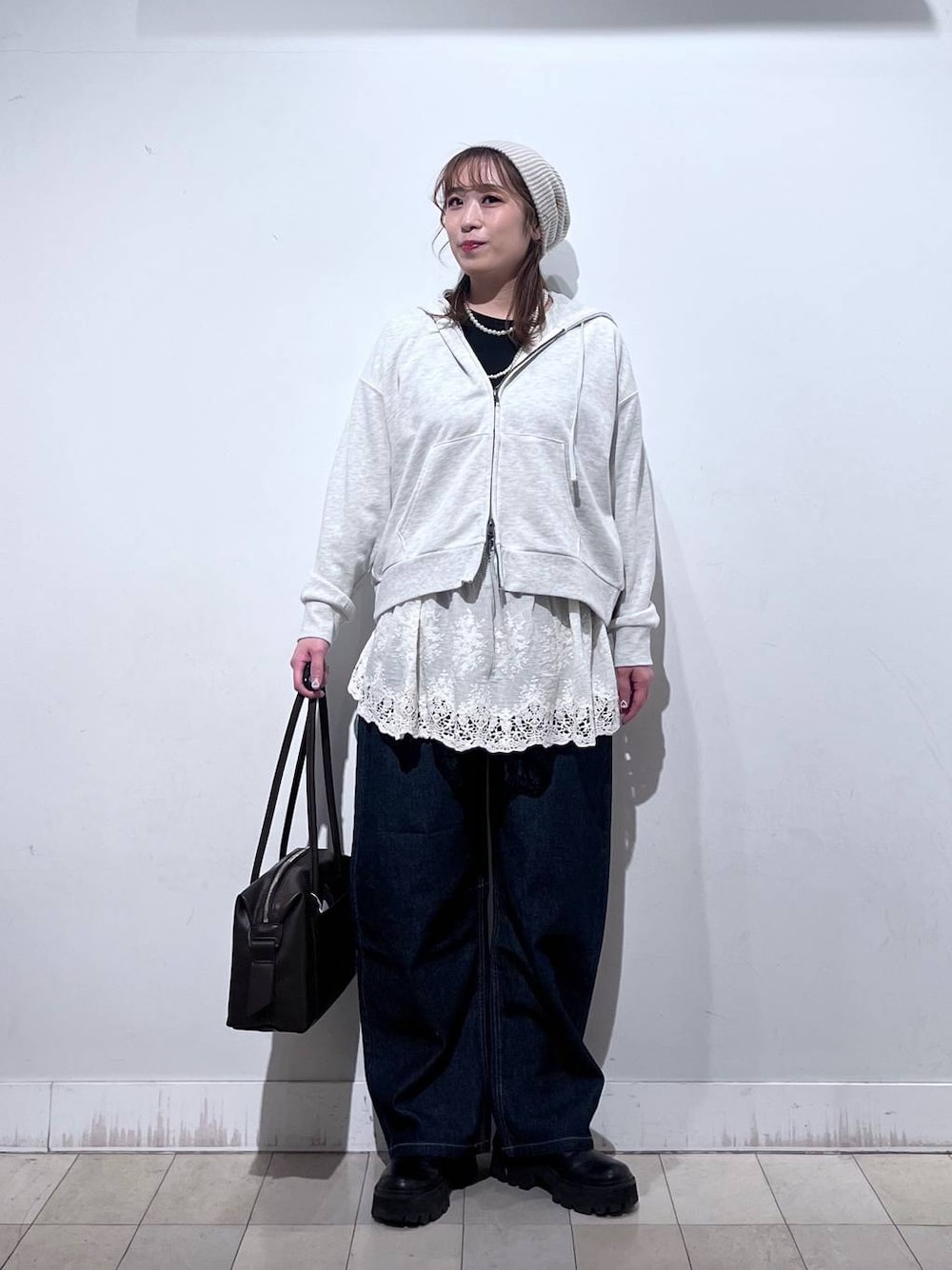 ブラウン系のボストンバッグ、ホワイト系のパーカー、ホワイト系のその他トップスを着用したレディースの冬コーディネートの1枚目の写真
