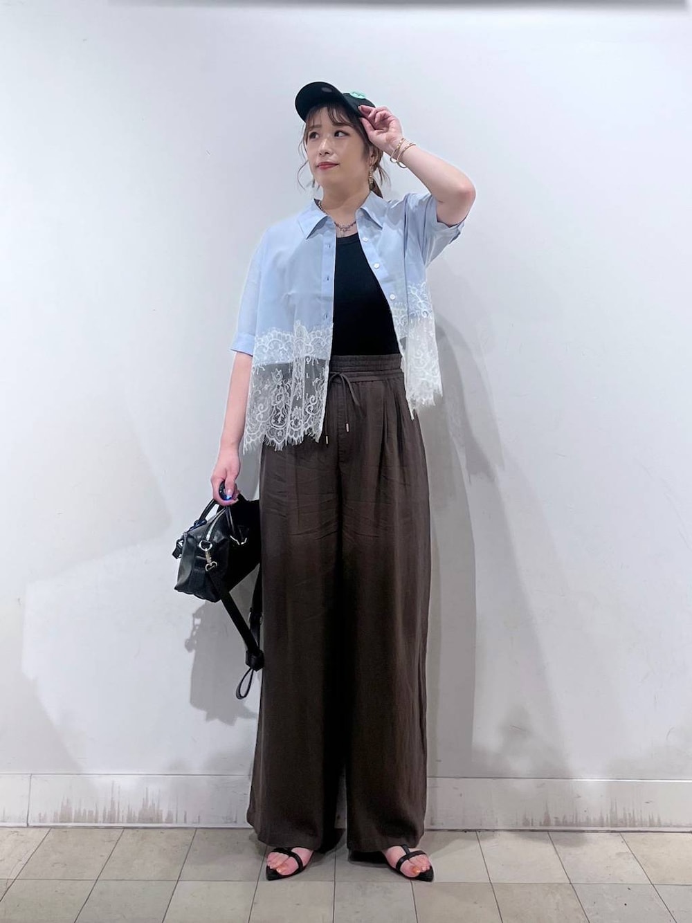 ブラウン系のその他パンツ、ブラック系のボストンバッグ、ブラック系のサンダルを着用したレディースの夏コーディネートの1枚目の写真
